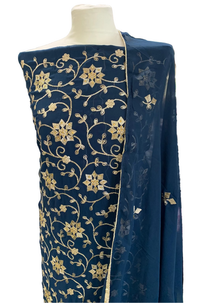 Navy blue fabric with gold floral patterns on a mannequin in a store setting.