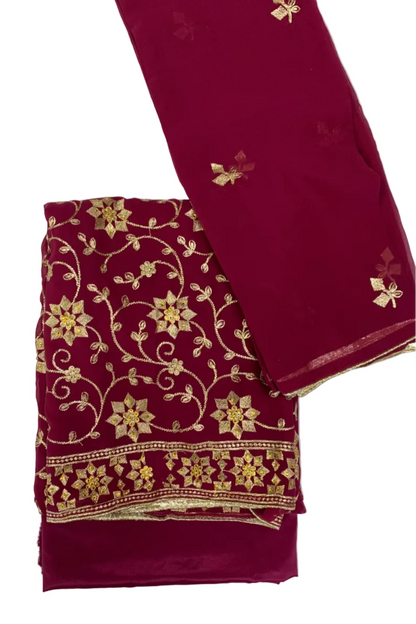 Pink fabric with gold floral embroidery on a white background