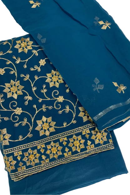 Turquoise fabric with gold floral embroidery on a white background