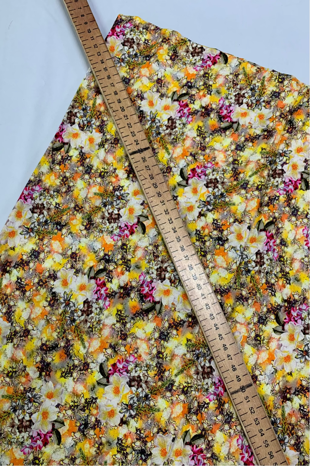 Floral fabric with a ruler for scale on a white background