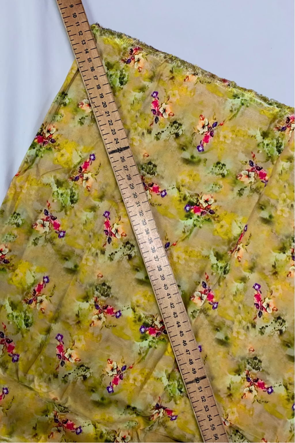 Floral-patterned fabric with a ruler for scale on a white background