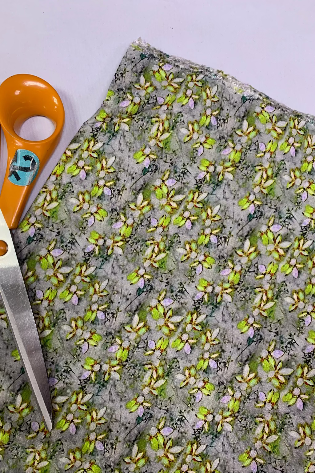 Fabric with floral pattern and scissors on a light background