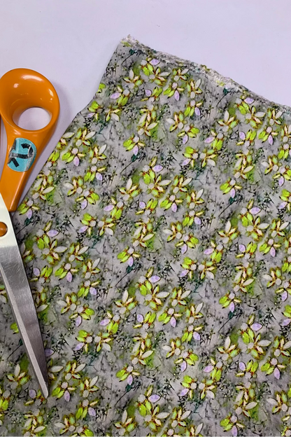 Fabric with floral pattern and scissors on a light background
