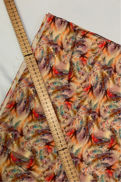 Colourful fabric with a floral pattern and a ruler for scale on a white background