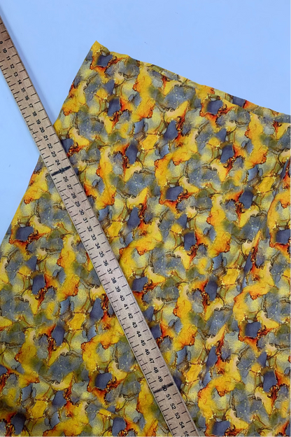 Colorful fabric with a pattern and a ruler for scale on a blue background