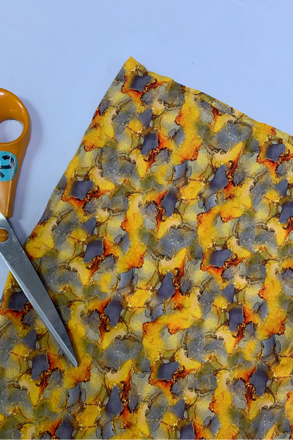 Colourful fabric with a pair of scissors on a light blue background