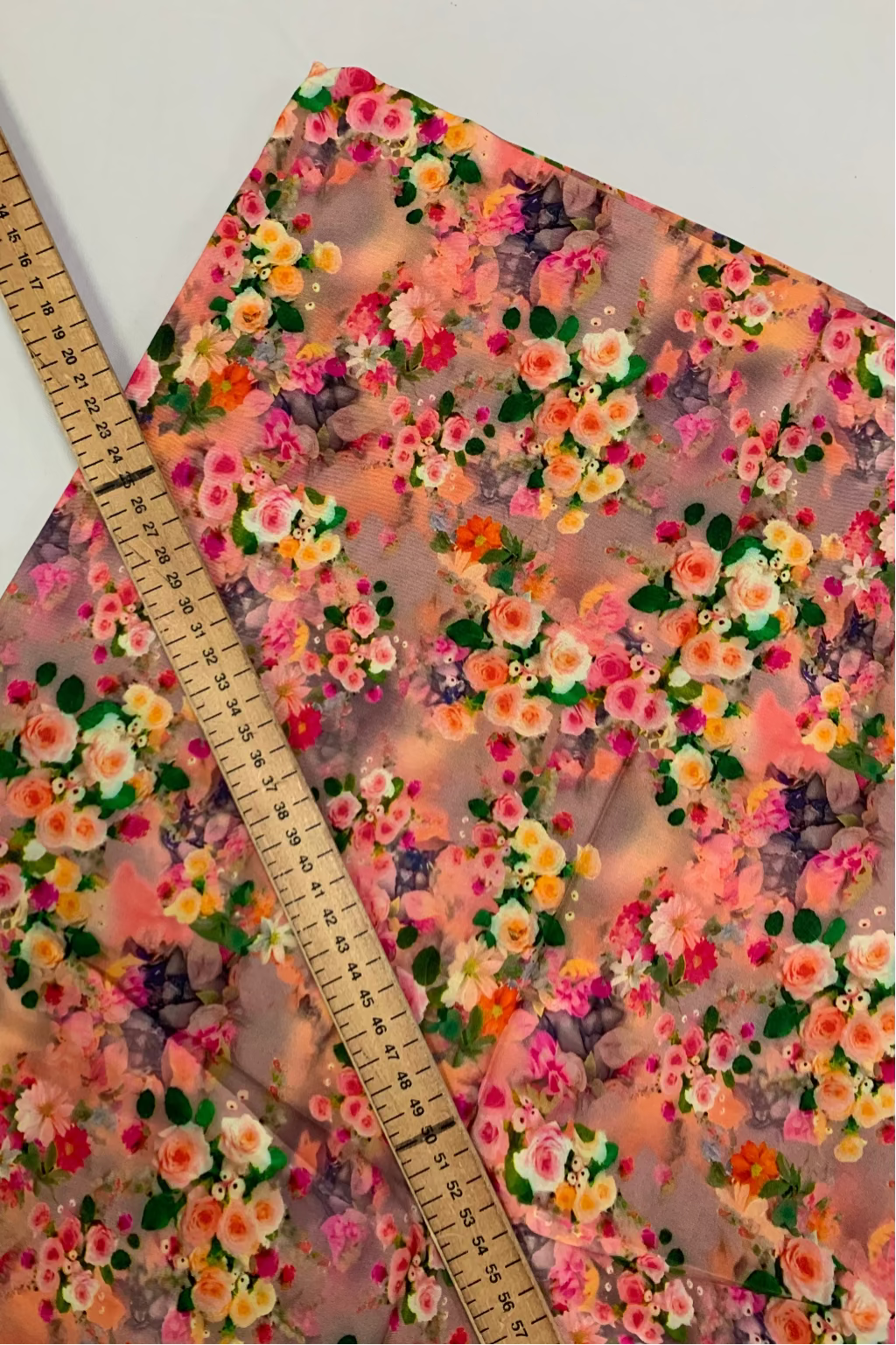Floral-patterned viscose fabric with a ruler for scale on a white background