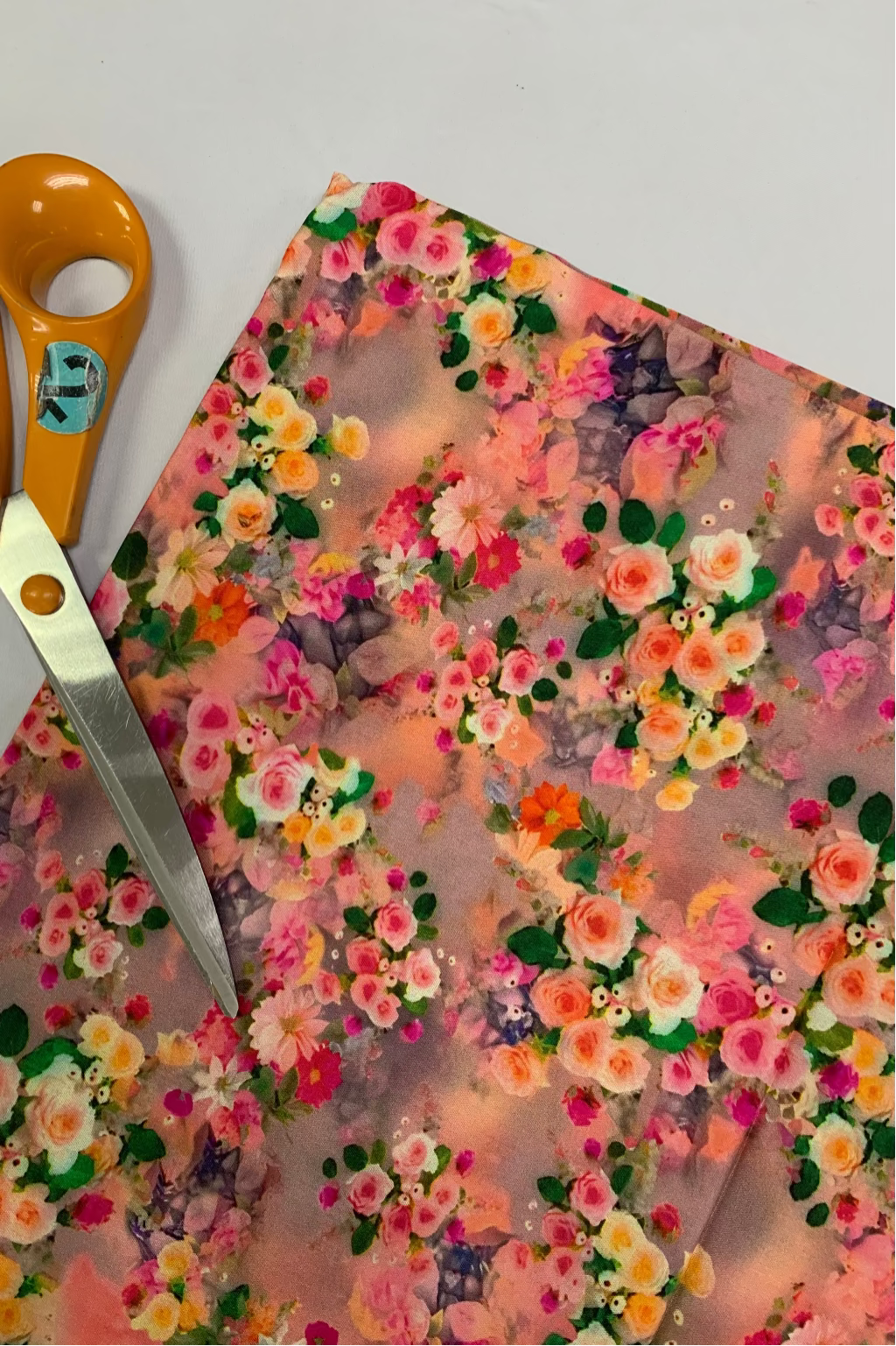 Floral fabric with a pair of scissors on a white background