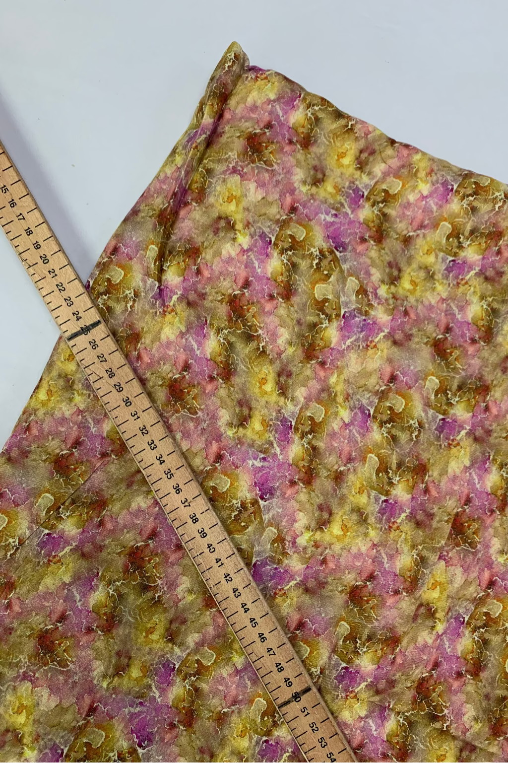 Floral fabric with a ruler for scale on a white background