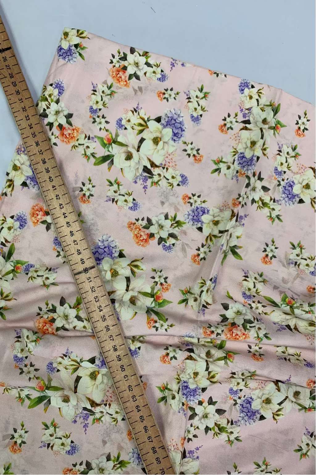 Floral fabric with a ruler for scale on a white background