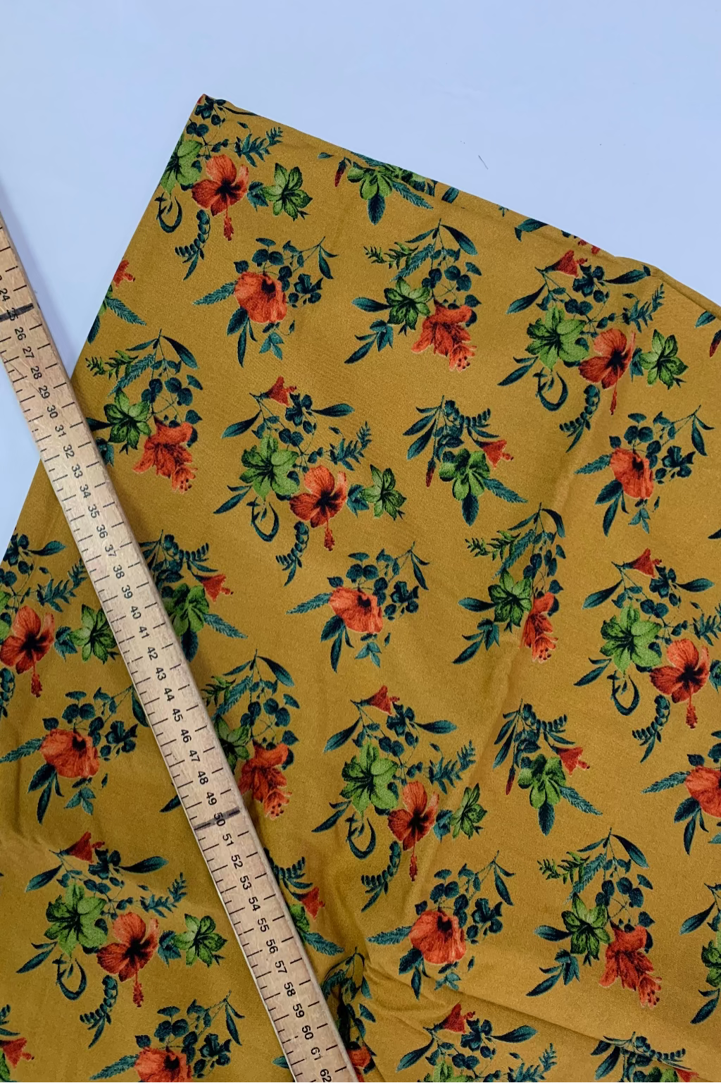 Floral fabric with a ruler for scale on a white background