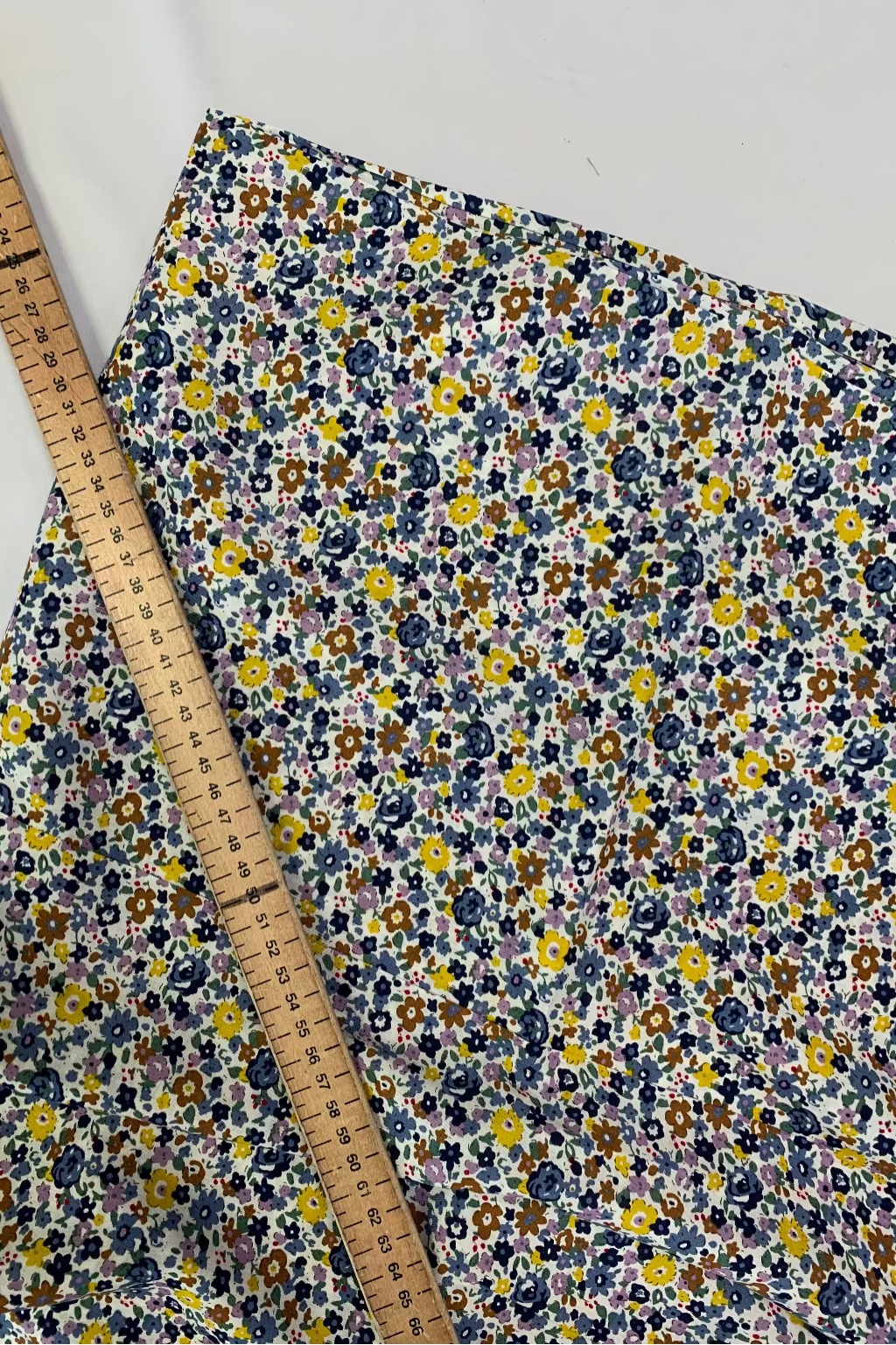 Floral fabric with a ruler for scale on a white background