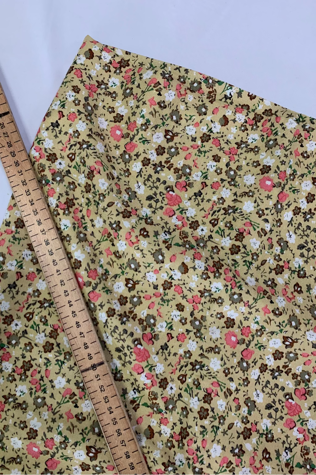 Floral fabric with a ruler for scale on a white background