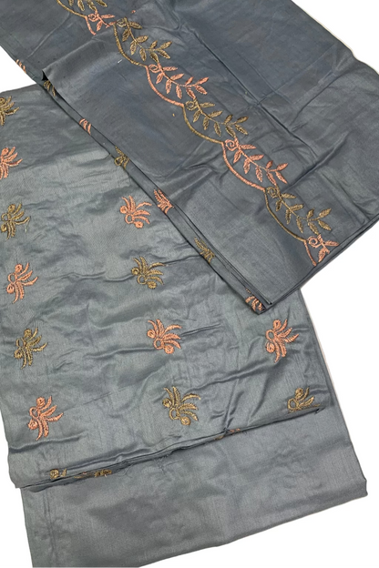 Blue fabric with orange and green embroidery on a white background