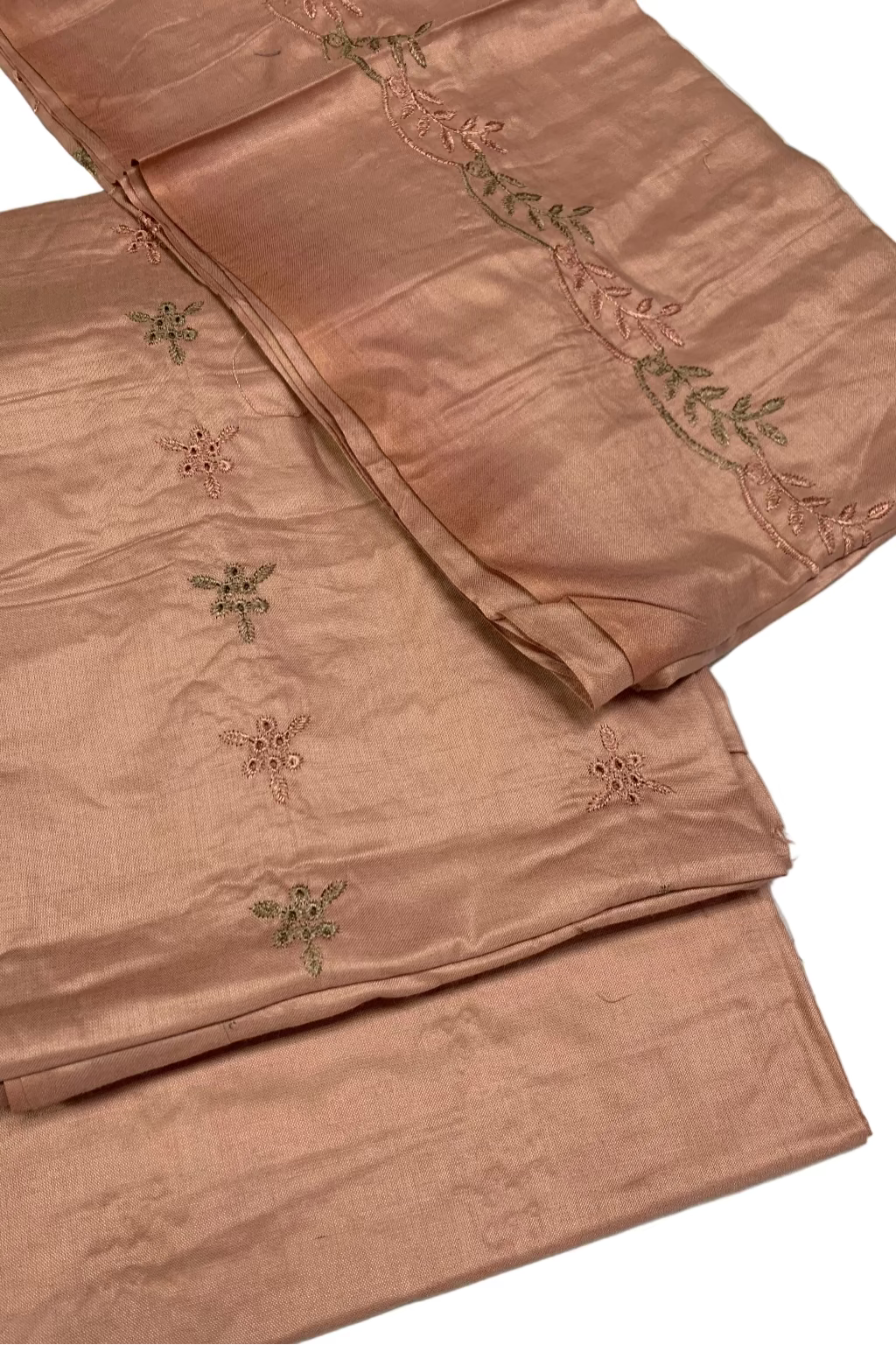 Folded pink fabric with embroidered patterns on a white background