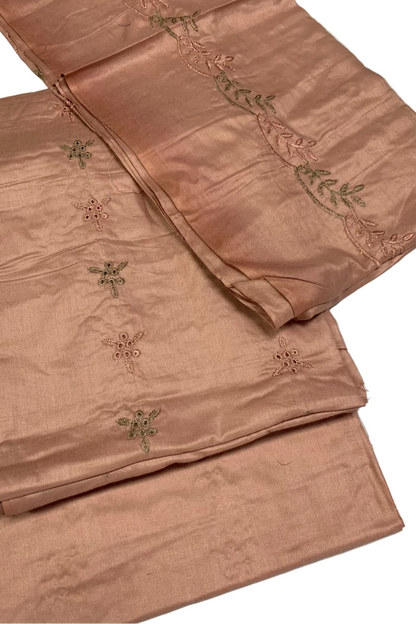 Folded pink fabric with embroidered patterns on a white background
