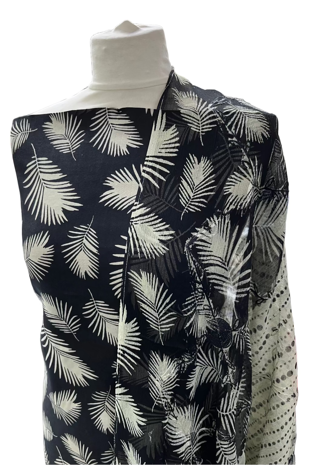 Mannequin wearing a black shirt with white leaf pattern in a fabric store.