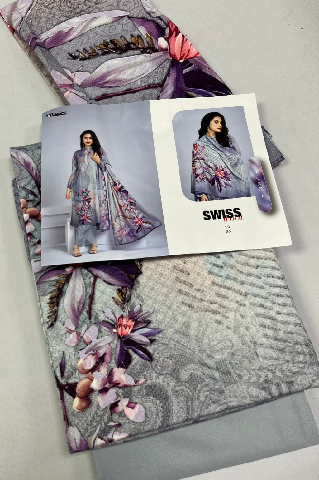 Floral patterned fabric with a magazine or catalog featuring a model wearing a similar outfit on a gray background.