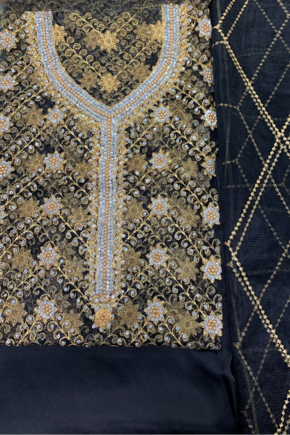 Black fabric with gold embroidery on a textured background