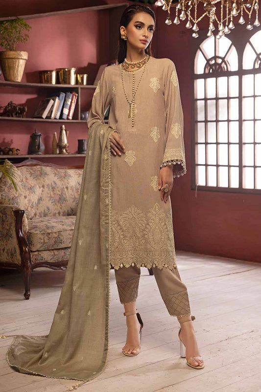 A woman modeling a beige three-piece salwar kameez suit with embroidered details.