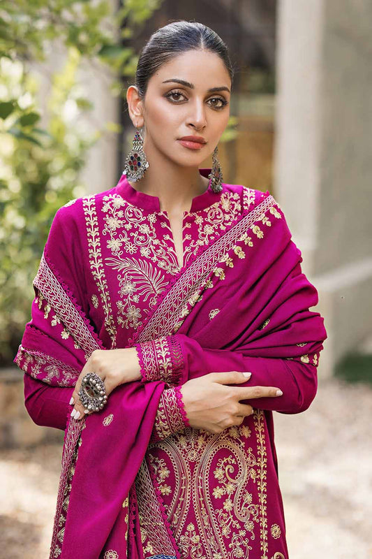 A woman wearing a traditional pink salwar kameez suit with embroidered details.